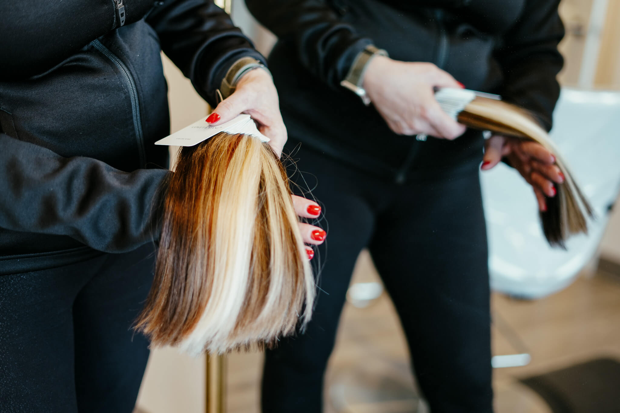 A stylist showing hand tied extensions colors and options.
